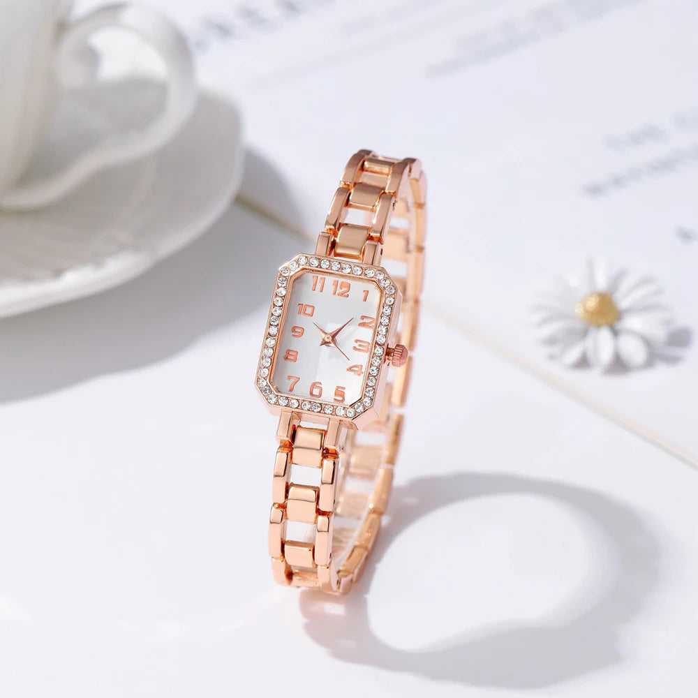 Rose gold watch with diamond accents on a light background