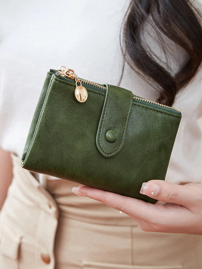 Green wallet held by a person with a blurred background