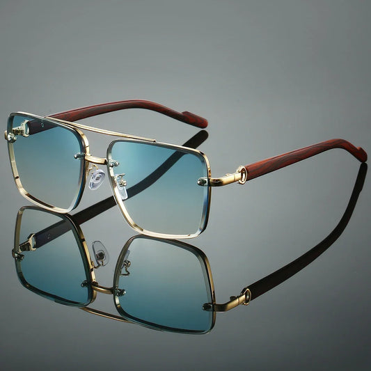 Sunglasses with gold frame and brown arms on a reflective surface with a gray background