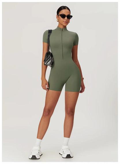 Woman wearing a green bodysuit with white sneakers on a light gray background