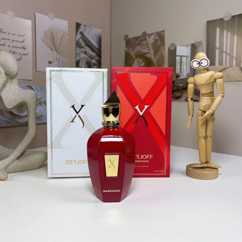 Red Xerjoff perfume bottle and packaging on a white surface with a wooden mannequin figure.