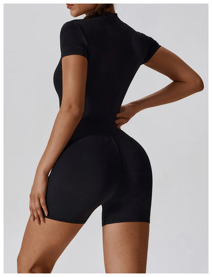 Person wearing a black bodysuit against a light gray background