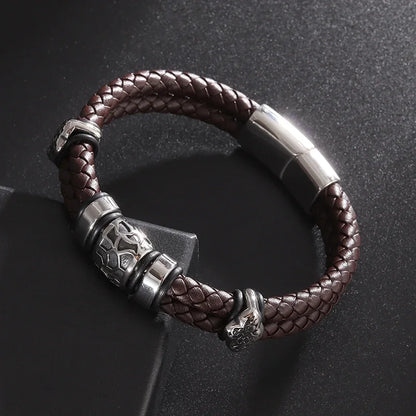 Brown braided leather bracelet with silver metal accents on a dark background