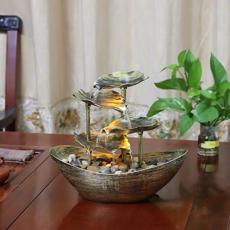 Tabletop water fountain with decorative elements on a wooden surface