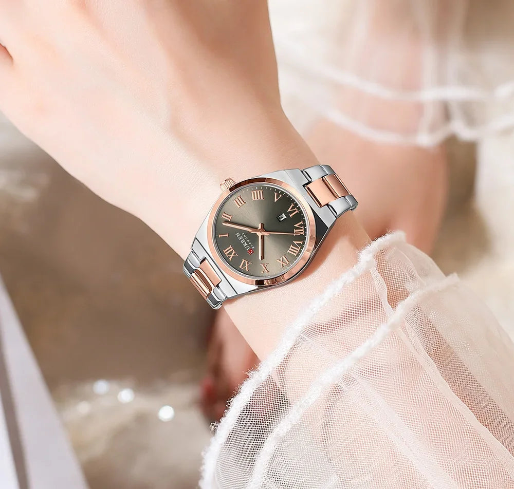 Wristwatch with rose gold and silver band on a blurred background