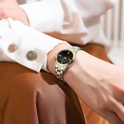 Gold and black watch on a wrist with a blurred background