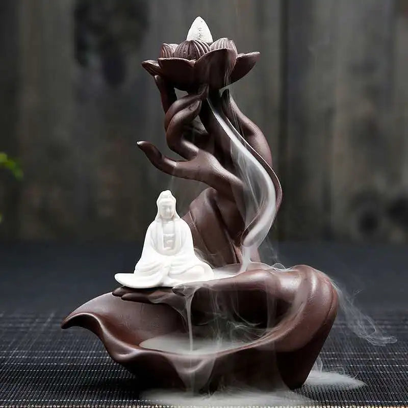 Decorative incense burner shaped like a lotus flower with a Buddha figure, emitting smoke.