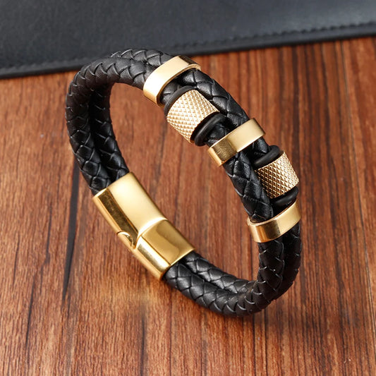Black braided leather bracelet with gold accents on a wooden surface