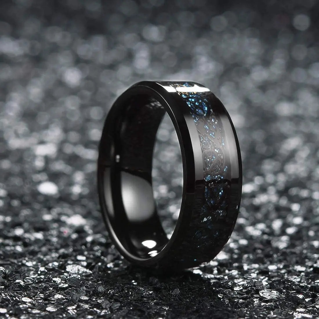 Black ceramic ring with silver inlay on a dark textured background