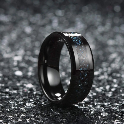 Black ceramic ring with silver inlay on a dark textured background
