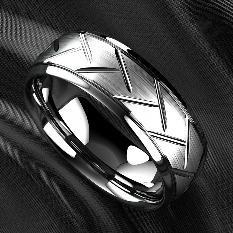 Silver ring with geometric design on a black fabric background