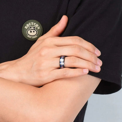 Person wearing a ring with a visible brand logo on a black shirt