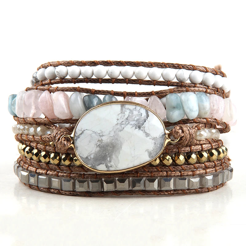 Stack of multi-layered bracelets with stones and leather on a white background