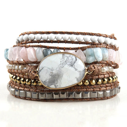 Stack of multi-layered bracelets with stones and leather on a white background