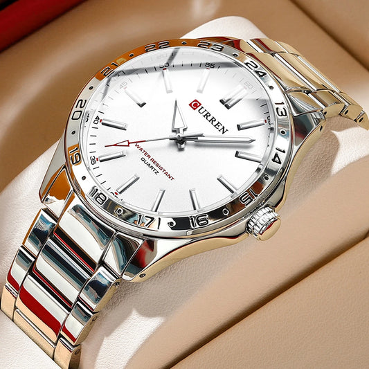 Silver wristwatch with white face on a beige surface