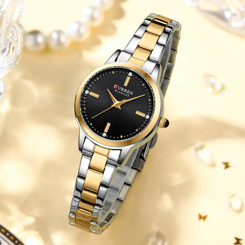 Gold and silver watch with black dial on a decorative background