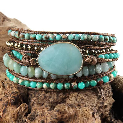 Turquoise beaded bracelet with a large central stone on a wooden surface