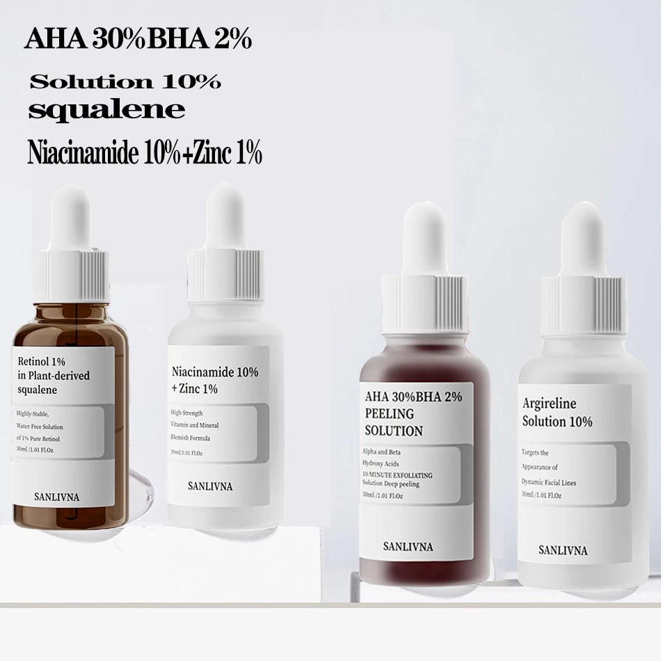 Four skincare serum bottles with labels on a light gray background