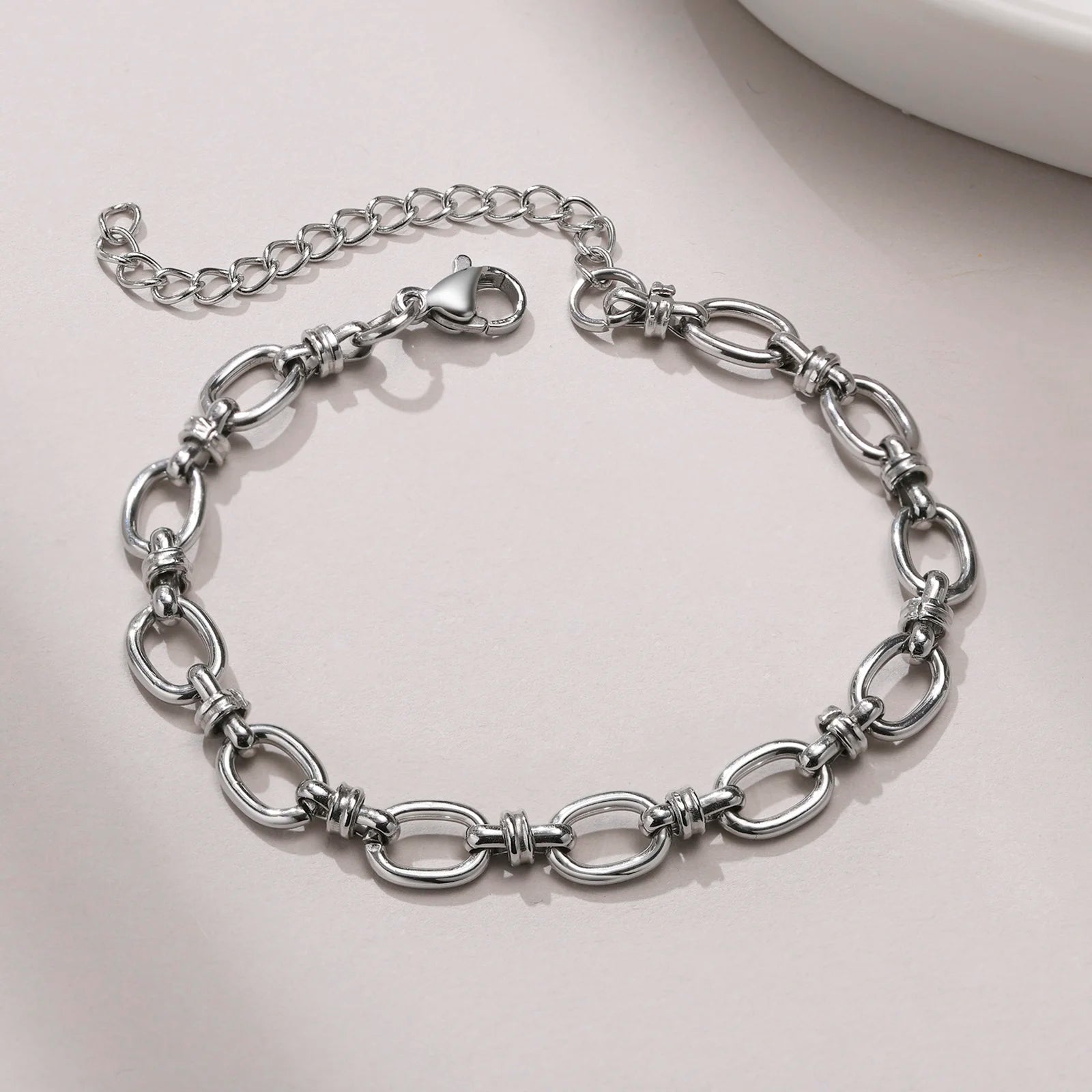 Silver chain bracelet on a light gray surface