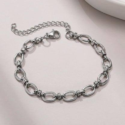 Silver chain bracelet on a light gray surface