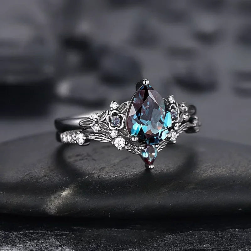 Silver ring with a blue gemstone on a dark surface