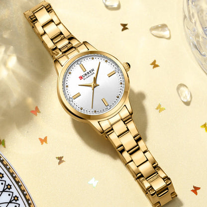 Gold wristwatch with a white face on a decorative background