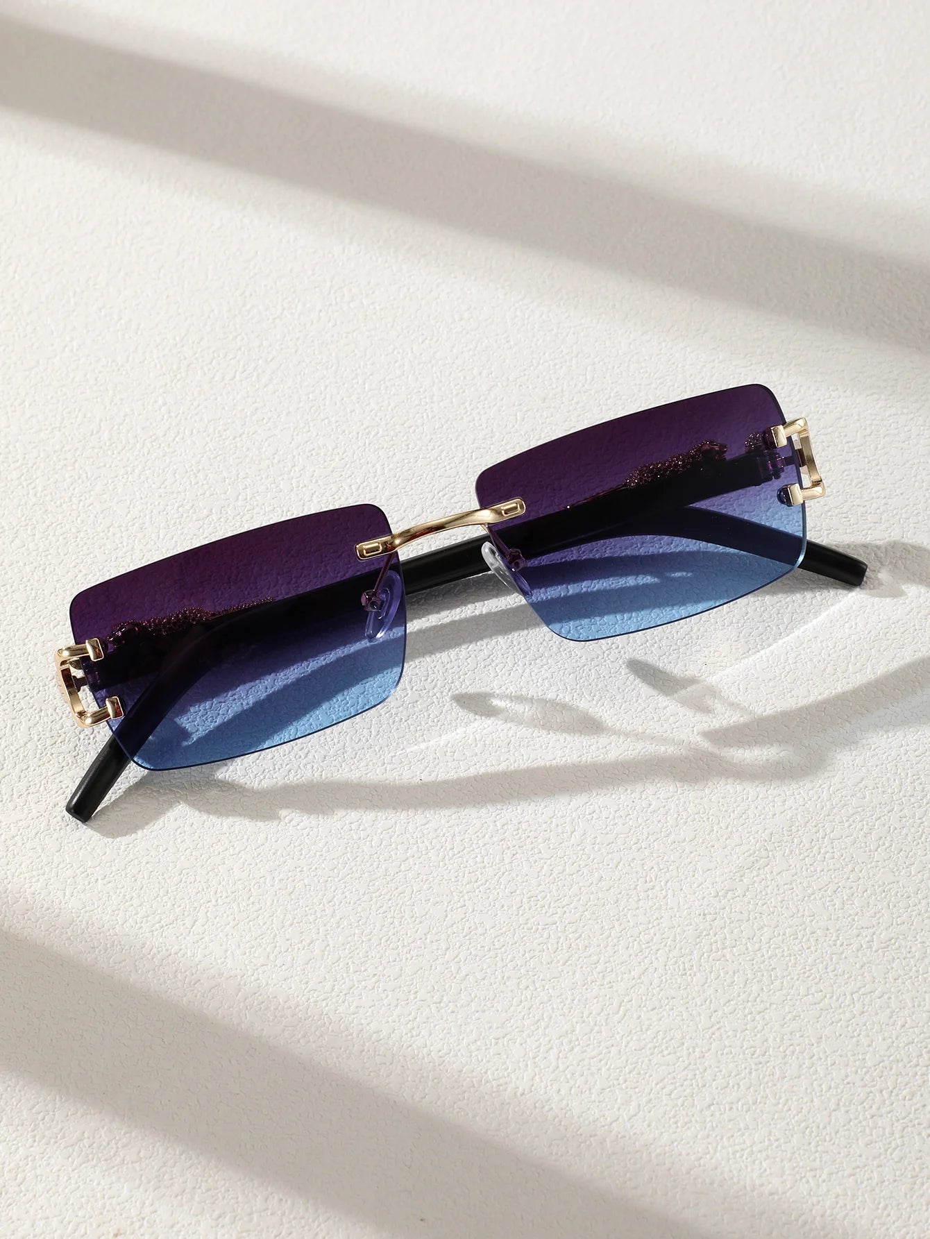 Sunglasses with purple and blue gradient lenses on a white background