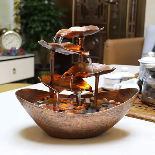 Wooden water fountain with leaf design on a table