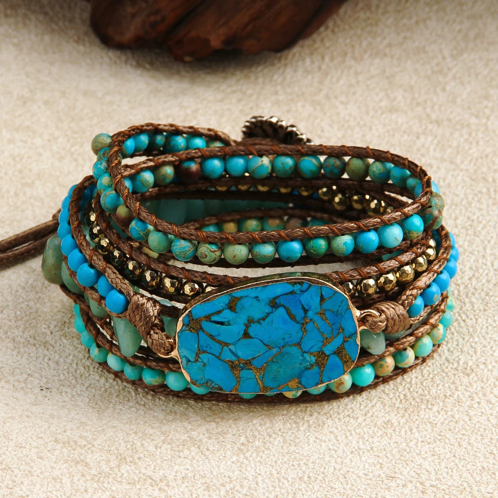Turquoise beaded bracelet with a large turquoise stone on a beige surface
