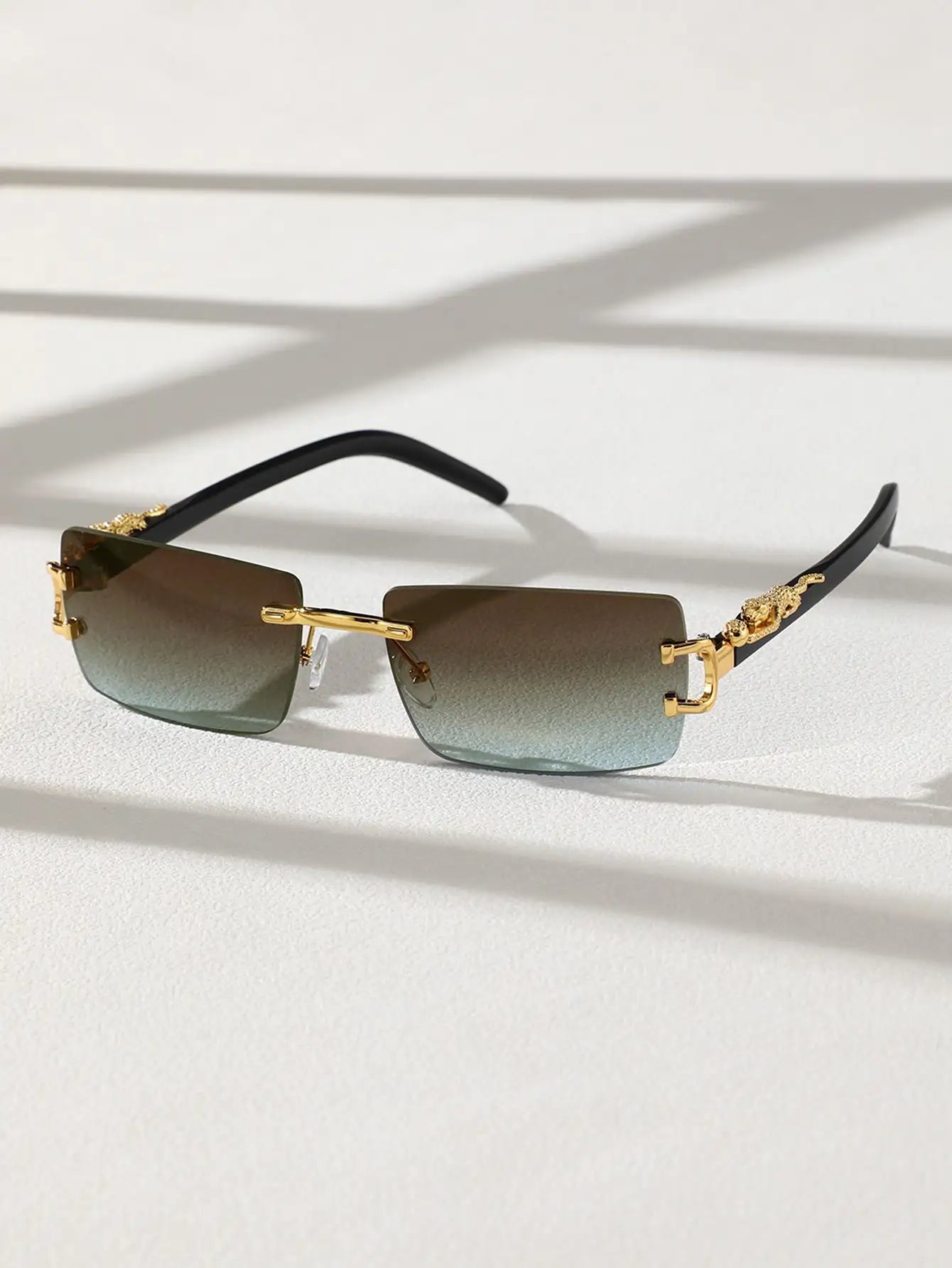 Sunglasses with gold frames and gradient lenses on a light background