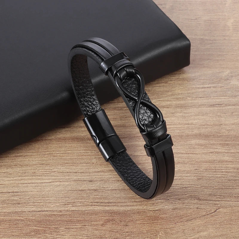 Black leather bracelet with an infinity symbol on a wooden surface