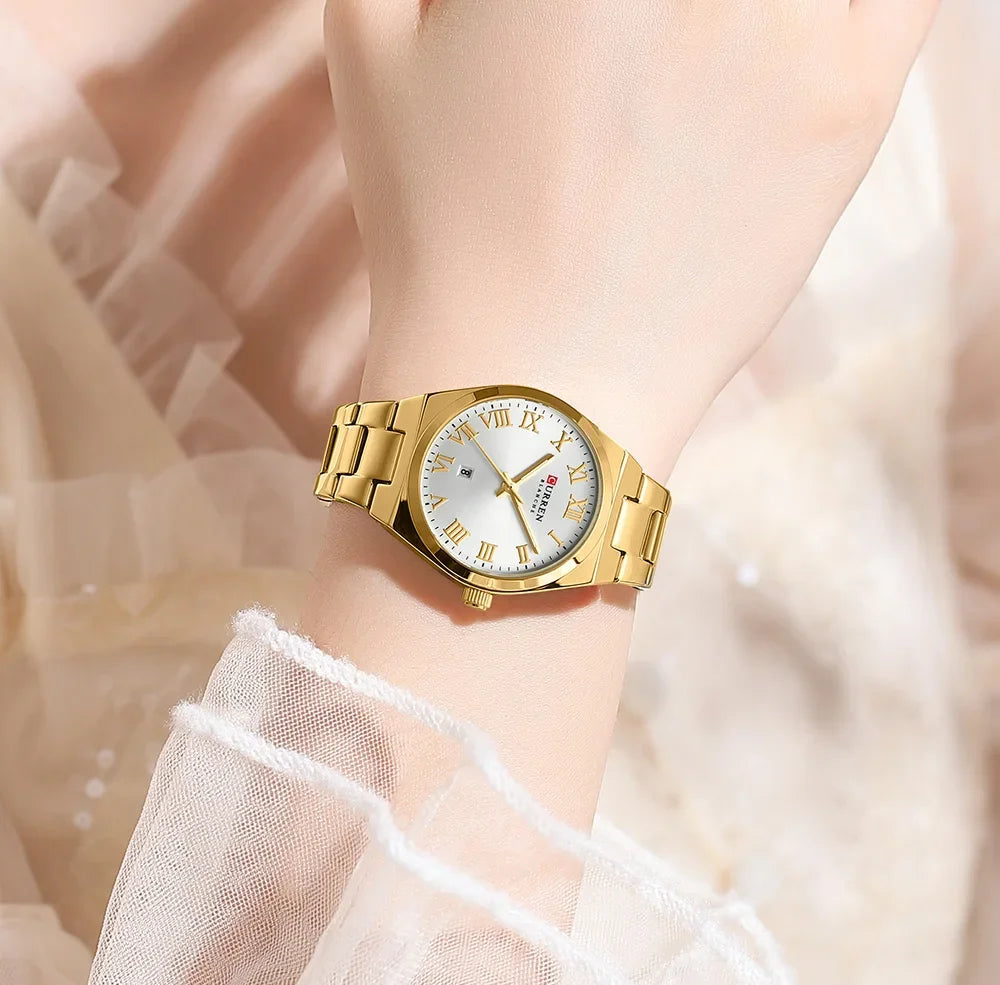 Gold wristwatch on a wrist with a soft, blurred background