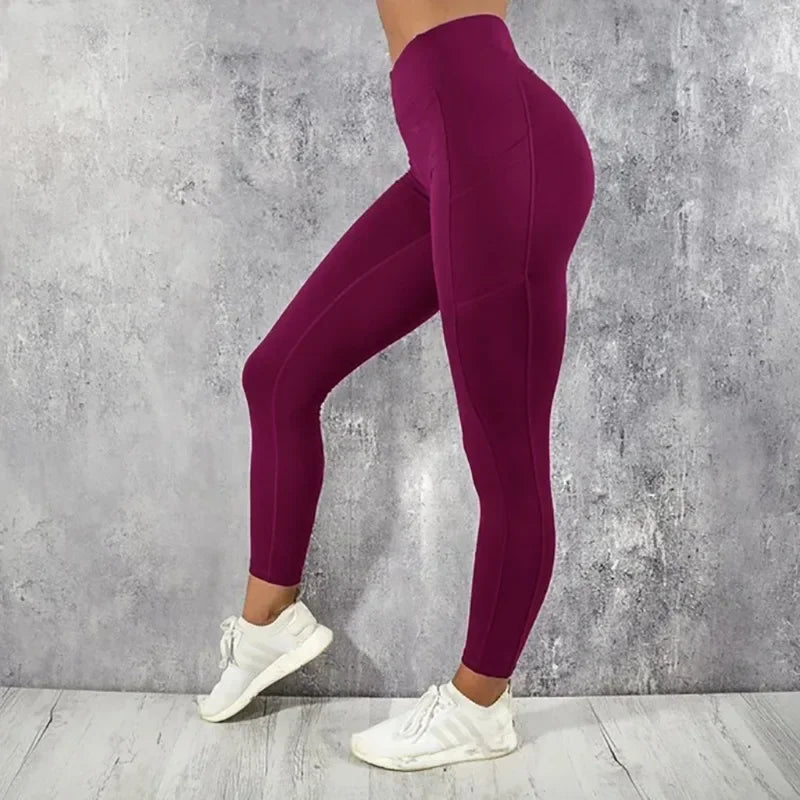 Purple leggings worn by a person against a gray concrete wall.