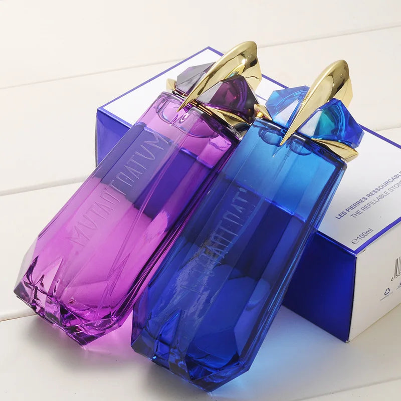 Two purple and blue perfume bottles with gold caps on a white surface.