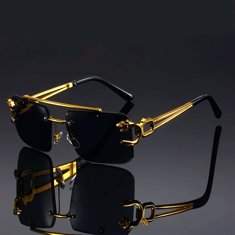 Gold-framed sunglasses with black lenses on a reflective surface