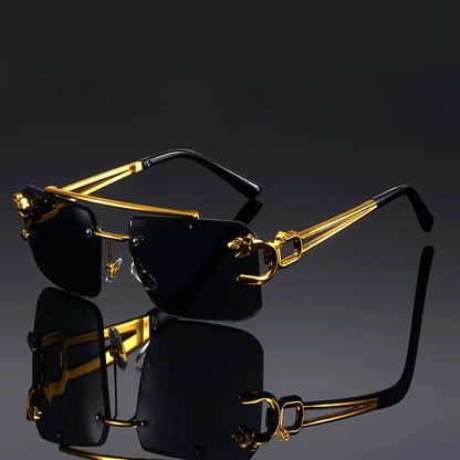 Gold-framed sunglasses with black lenses on a reflective surface