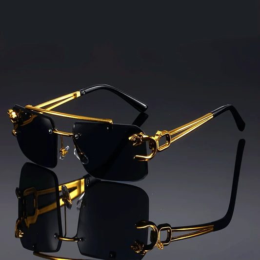Gold-framed sunglasses with black lenses on a reflective surface