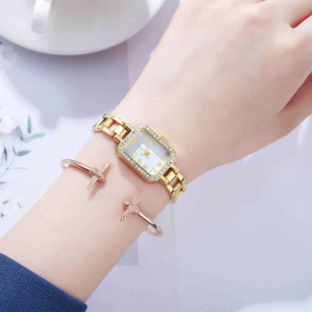 Gold watch on a wrist with a white background