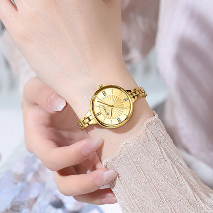 Gold wristwatch on a person's wrist with a blurred background