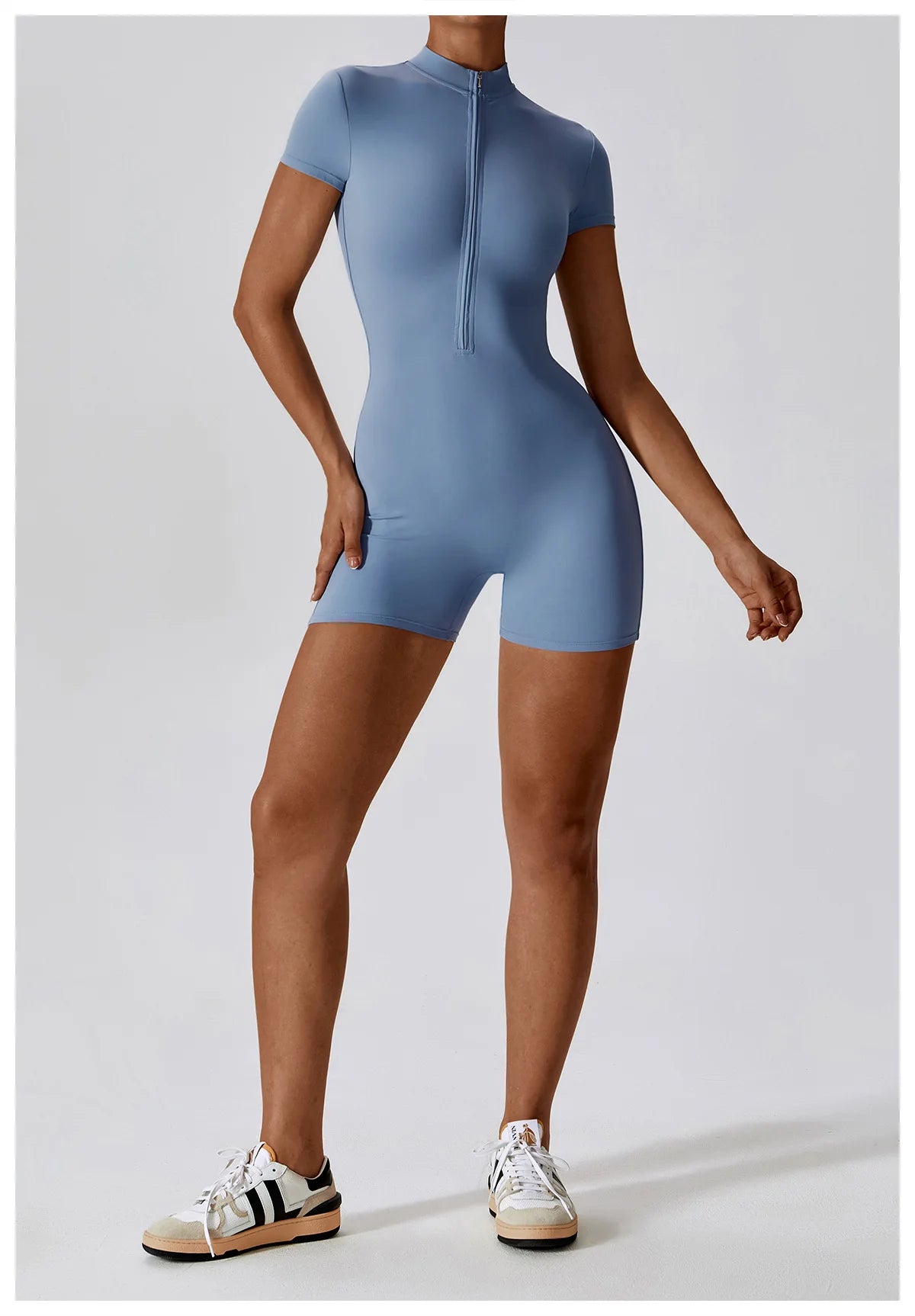 Person wearing a blue bodysuit on a light gray background