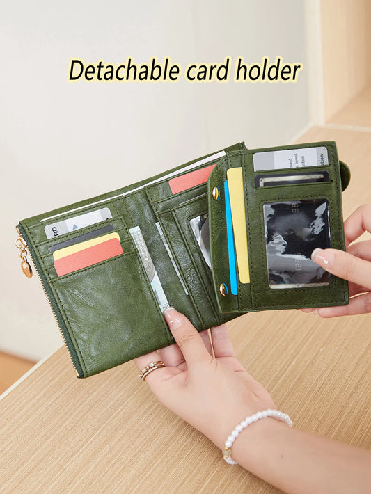 Green wallet with detachable card holder held by a hand on a wooden surface.