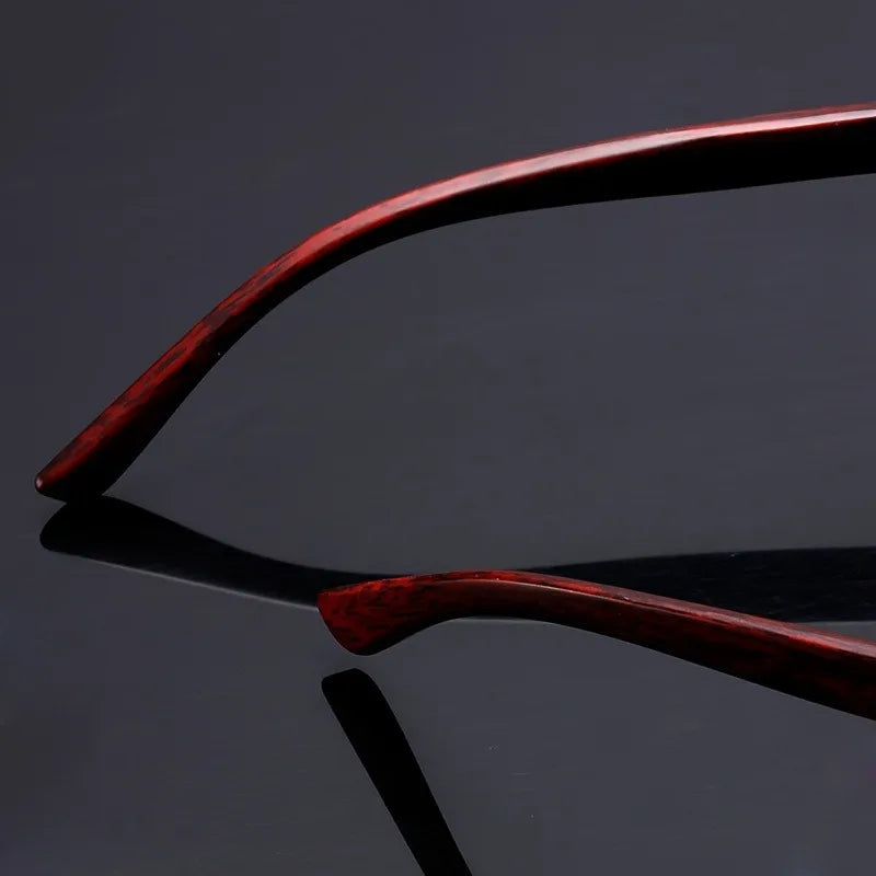 Close-up of a red wooden chair on a reflective black surface with a dark background
