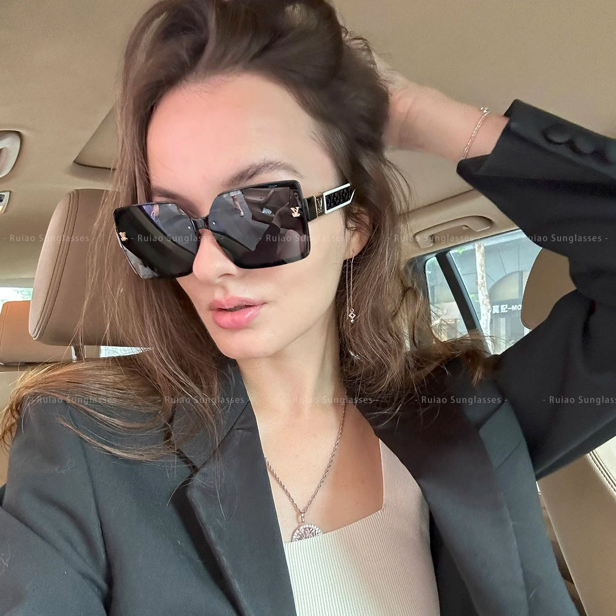 Woman wearing black sunglasses inside a car