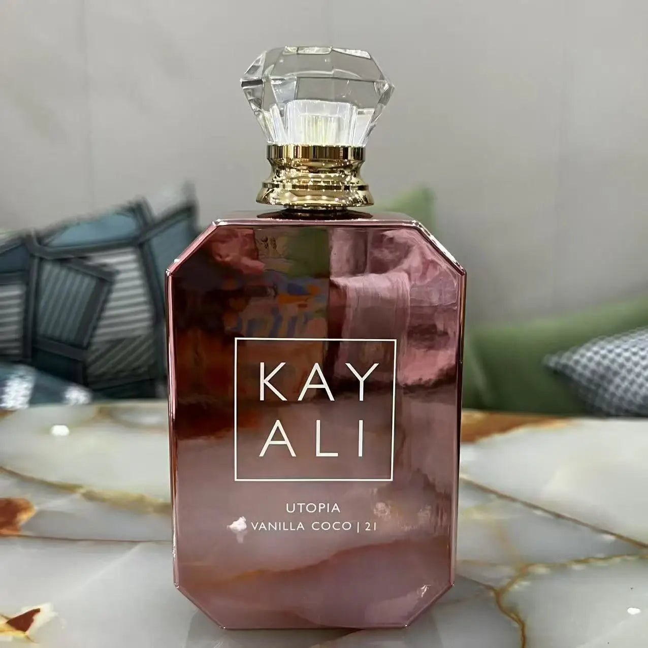 Perfume bottle with 'KAY ALI' branding on a marble surface