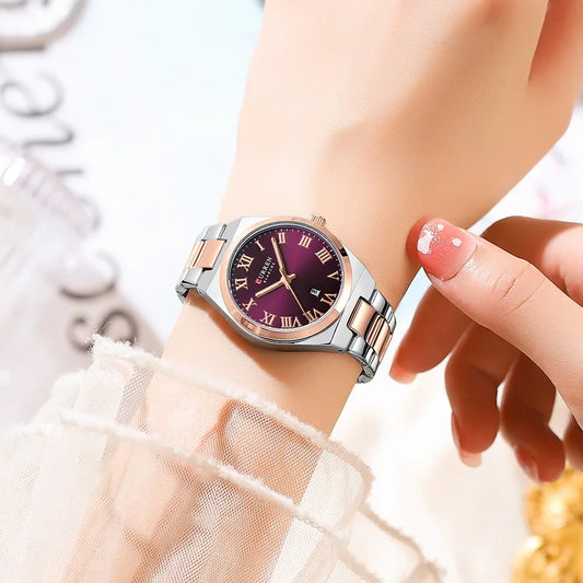 Wristwatch with a purple face and rose gold accents on a wrist.