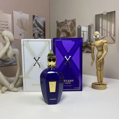 Erjoff Accento perfume bottle and packaging on a surface with decorative items in the background