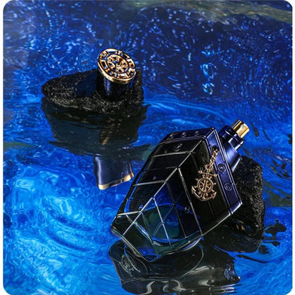 Black and gold perfume bottle with decorative cap on a blue water background
