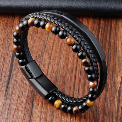 Black braided leather and beaded bracelet on a wooden surface