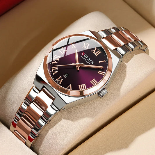Silver watch with purple face and rose gold accents on a beige surface