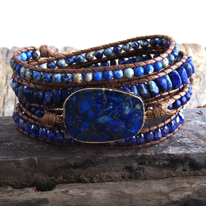 Multistrand bracelet with blue beads and a large blue stone on a wooden surface